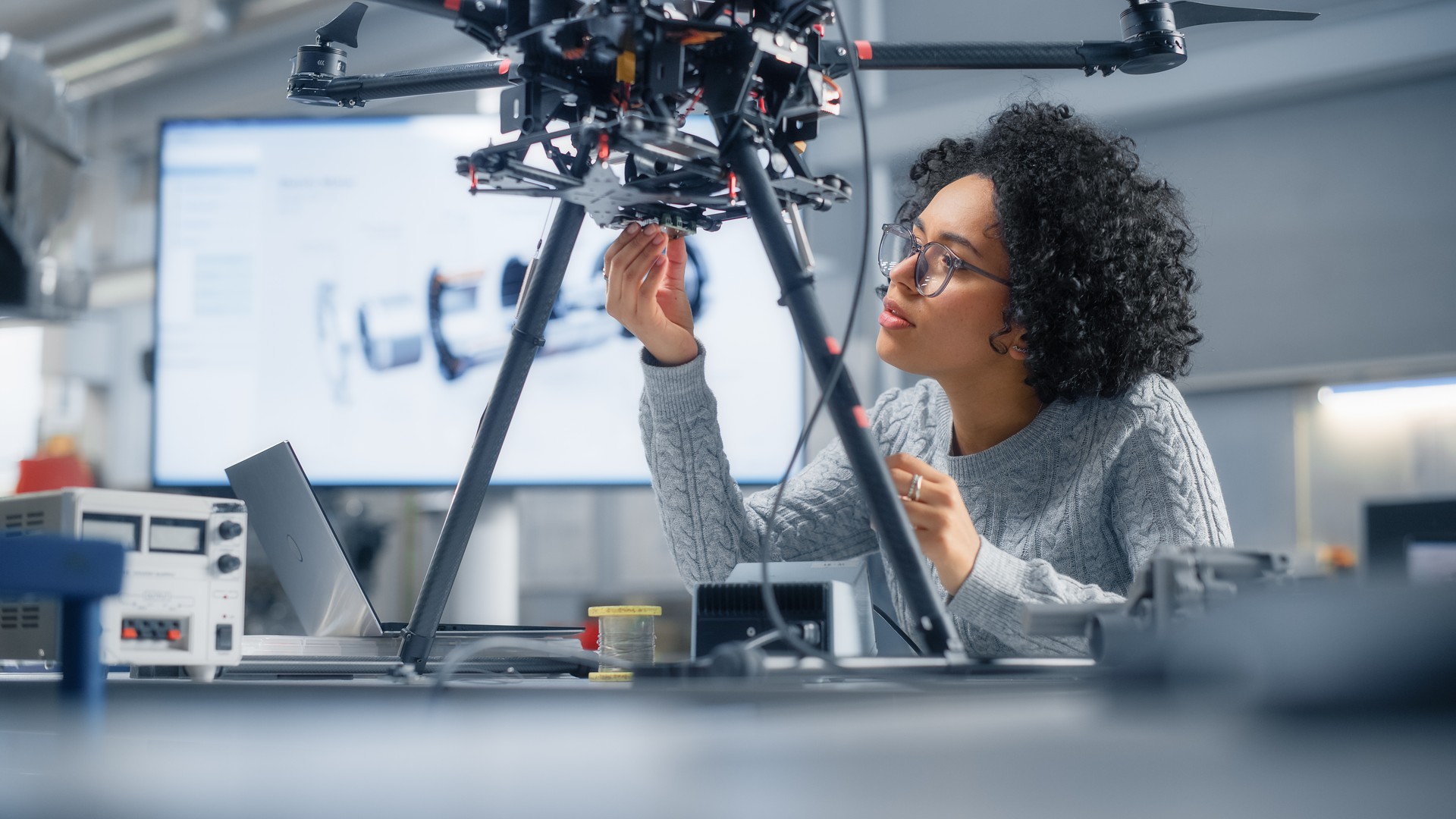 Concentrée d’ingénieures noires écrivant du code. Développement d’un logiciel pour le contrôle moderne des drones dans le laboratoire du centre de recherche. Concept de percée technologique dans les industries de vol.